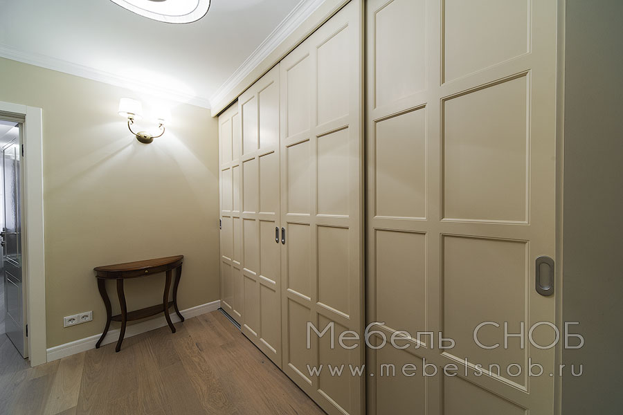 Внутри шкафа находятся секции с вешалами для длинной и короткой одежды, полки для хранения и выдвижные ящики с доводчиками. Внутри шкафа находятся секции с вешалами для длинной и короткой одежды, полки для хранения и выдвижные ящики с доводчиками.