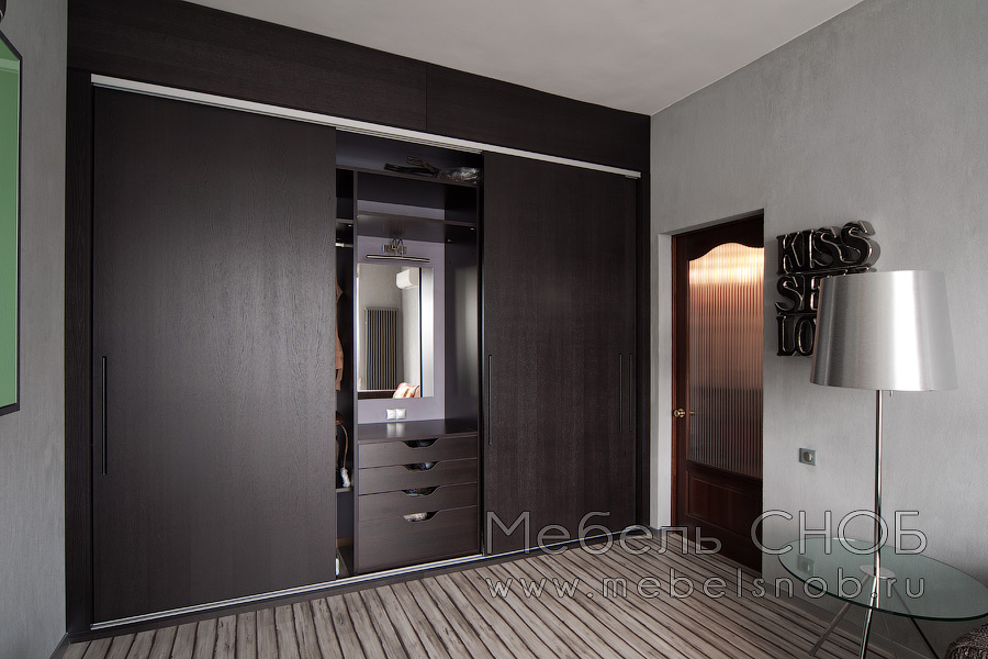 Черная корпусная мебель гармонично сочетается со стенами напольным покрытием, а яркие детали на элементах мебели, разноцветный диван, оригинальные декоративные украшения придают интерьеру глубину и стиль. Черная корпусная мебель гармонично сочетается со стенами напольным покрытием, а яркие детали на элементах мебели, разноцветный диван, оригинальные декоративные украшения придают интерьеру глубину и стиль.